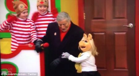 Miss Piggy braces singer Tony Bennett from falling off his float during the Macy's Thanksgiving Day Parade. 
